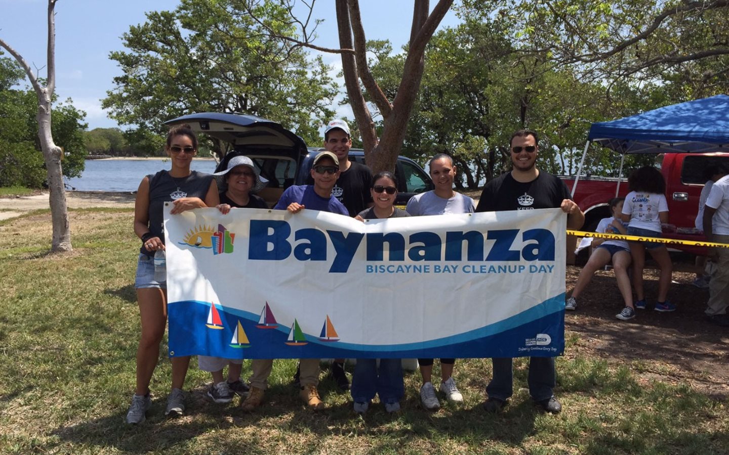 Grupo do dia de limpeza da Baía de Biscayne segurando o Banner de Baynanza