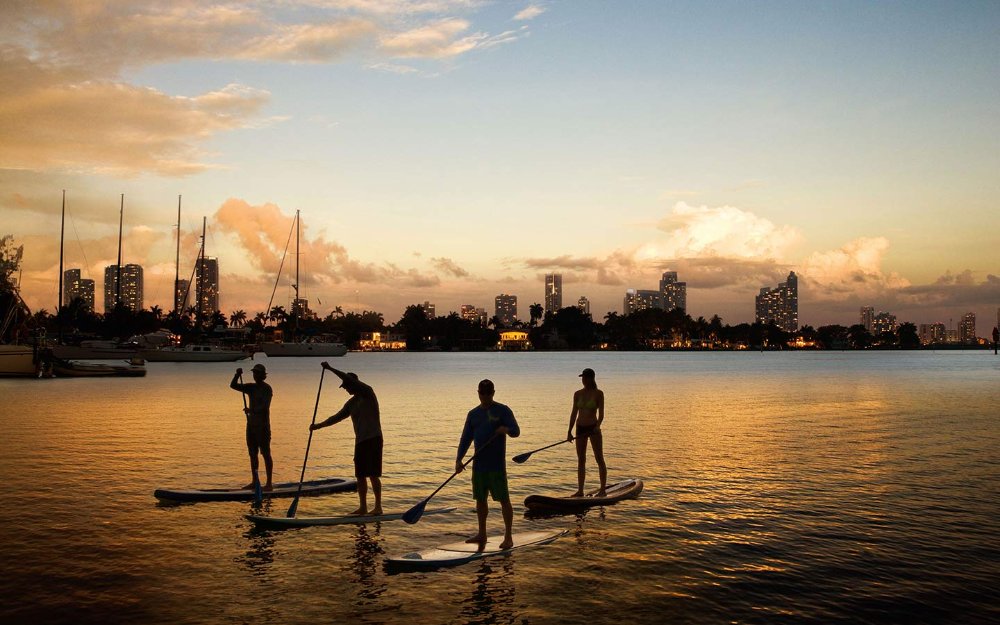 Paddleboarders ao entardecer