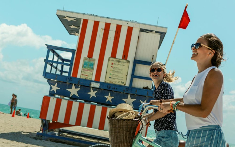 Amis sur South Beach marcher avec des vélos