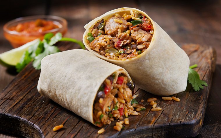 Burrito cut in half neatly on a plate