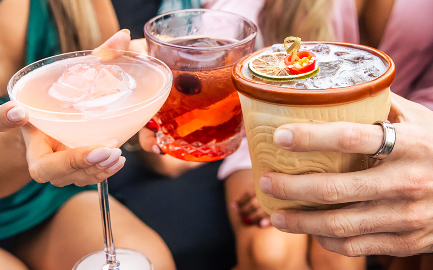 Friends raising cocktails together at Rosa Sky rooftop bar