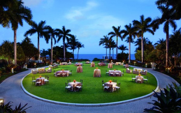 Réunion en plein air avec vue sur l'océan sur la pelouse du Ritz-Carlton Key Biscayne au crépuscule