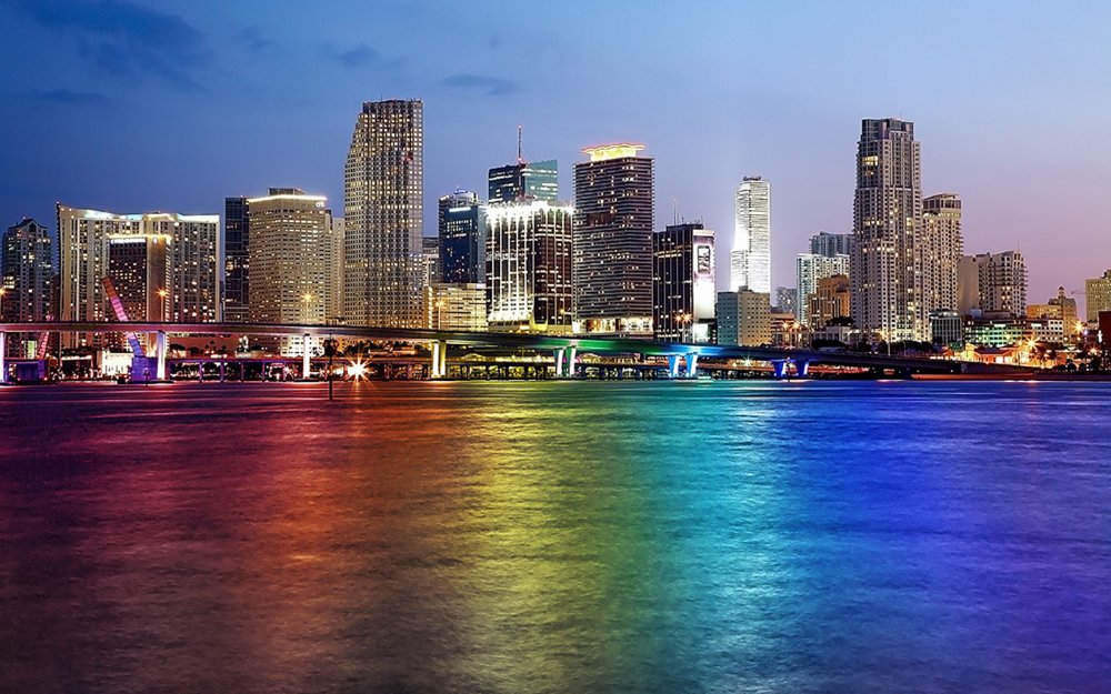Downtown Miami skyline with LGBTQ rainbow colors reflected on the bay