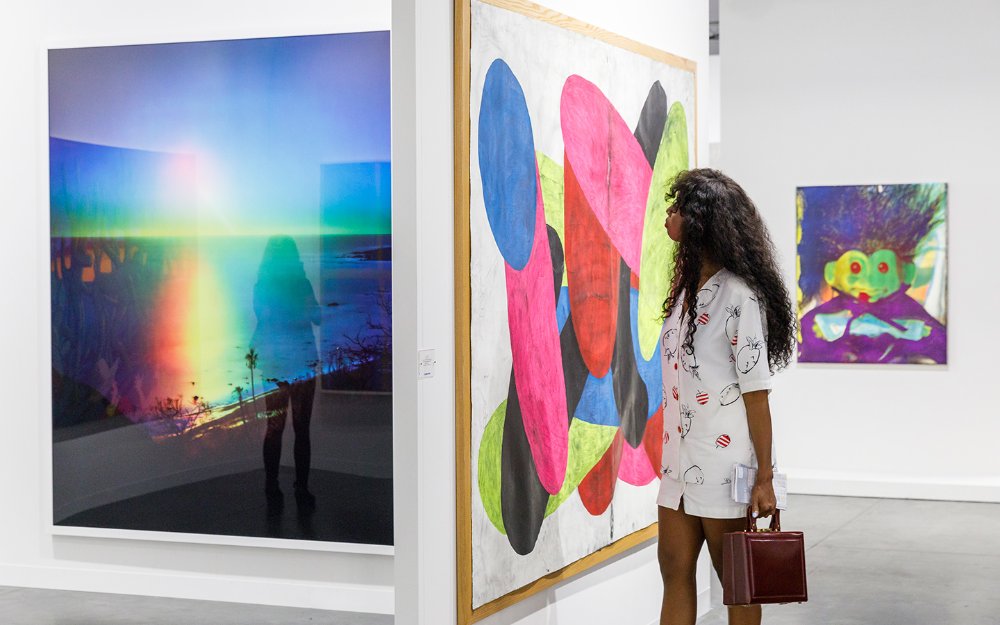 Young woman admiring painting during Art Basel
