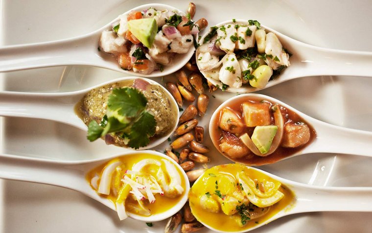 Spread of diverse dishes served on spoons at Jaguar restaurant