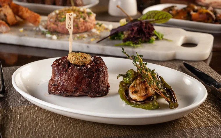 Grilled steak accompanied by sides and garnishes Grilled steak accompanied by sides and garnishes