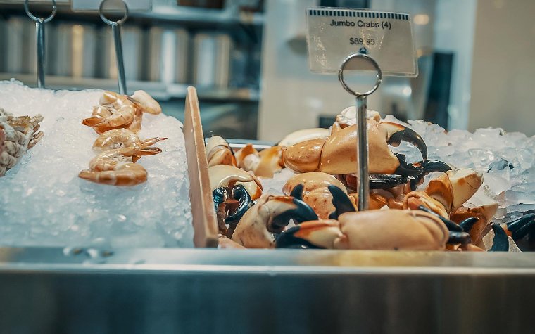 Chele di granchio di pietra e gamberi nella custodia dei frutti di mare al Joe's Stone Crab