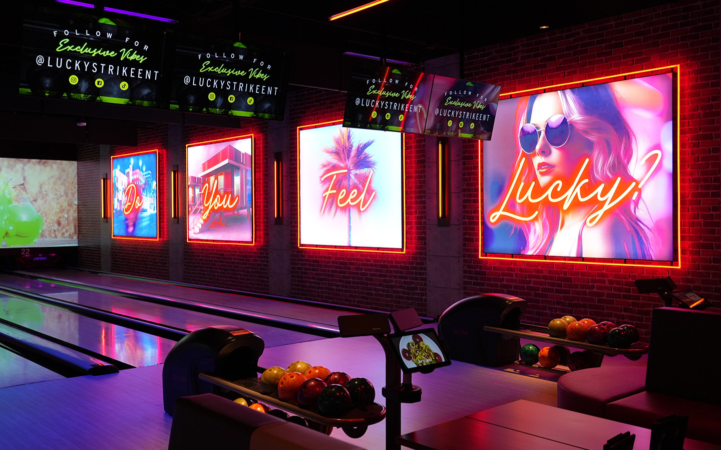 A neon wall and bowling lanes at Lucky Strike