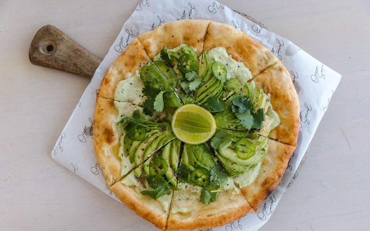 Avocado pizza with fresh greens served at Ocean Social Avocado pizza with fresh greens served at Ocean Social