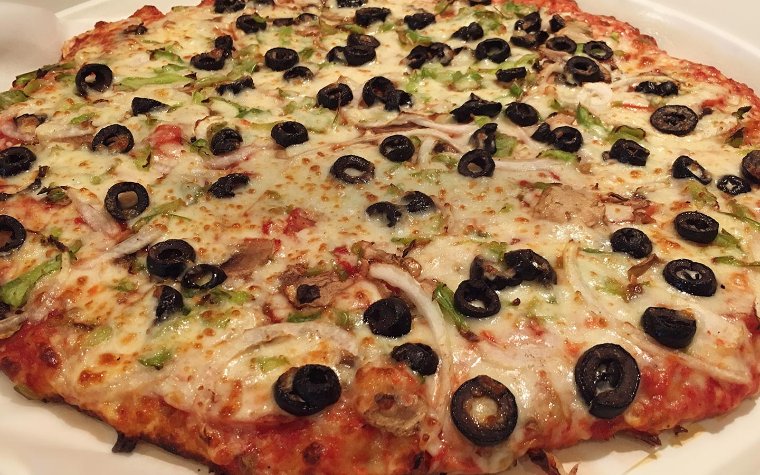 Close-up of pizza with olives & onions Pizza at Sir Pizza