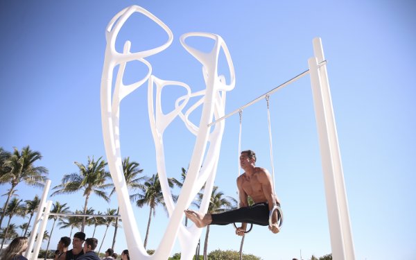 Мужчина на кольцах в Lummus Park на South Beach