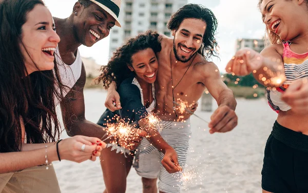 Freunde zünden Wunderkerzen am Strand an