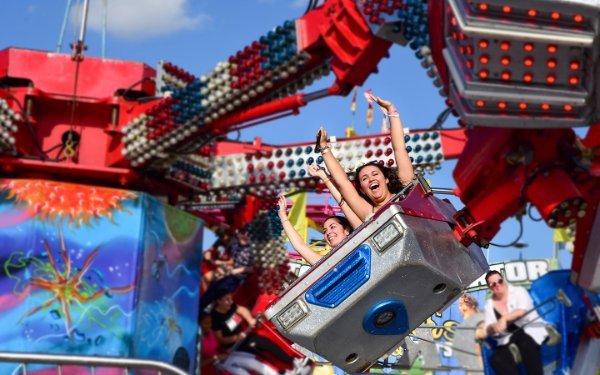 Manos arriba en una atracción en la Feria de la Juventud