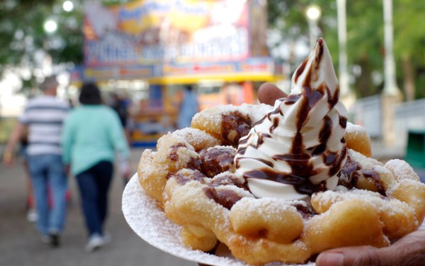 Funnel cake topped with ice cream and chocolate syrum